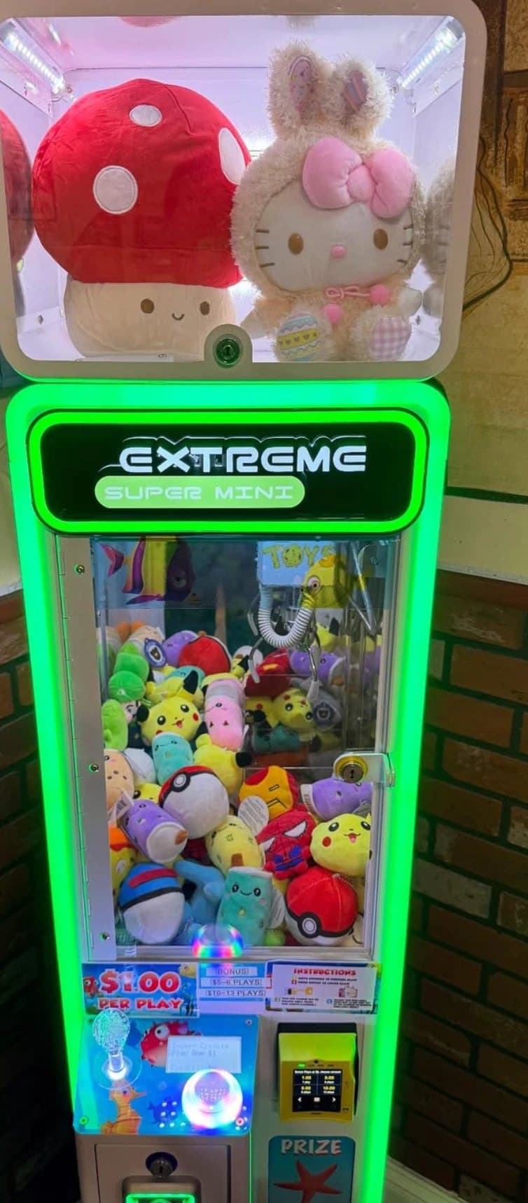 A compact Super Mini claw machine in a pizzeria, stocked with Pikachu and Poké Ball plushies